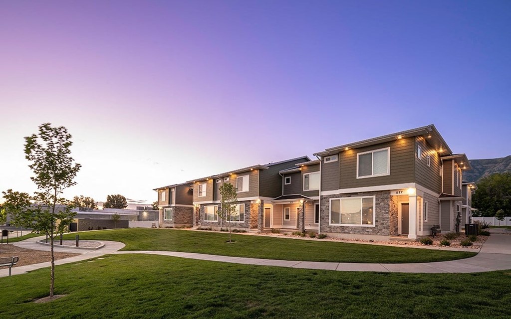 a house with lights on and a sidewalk
