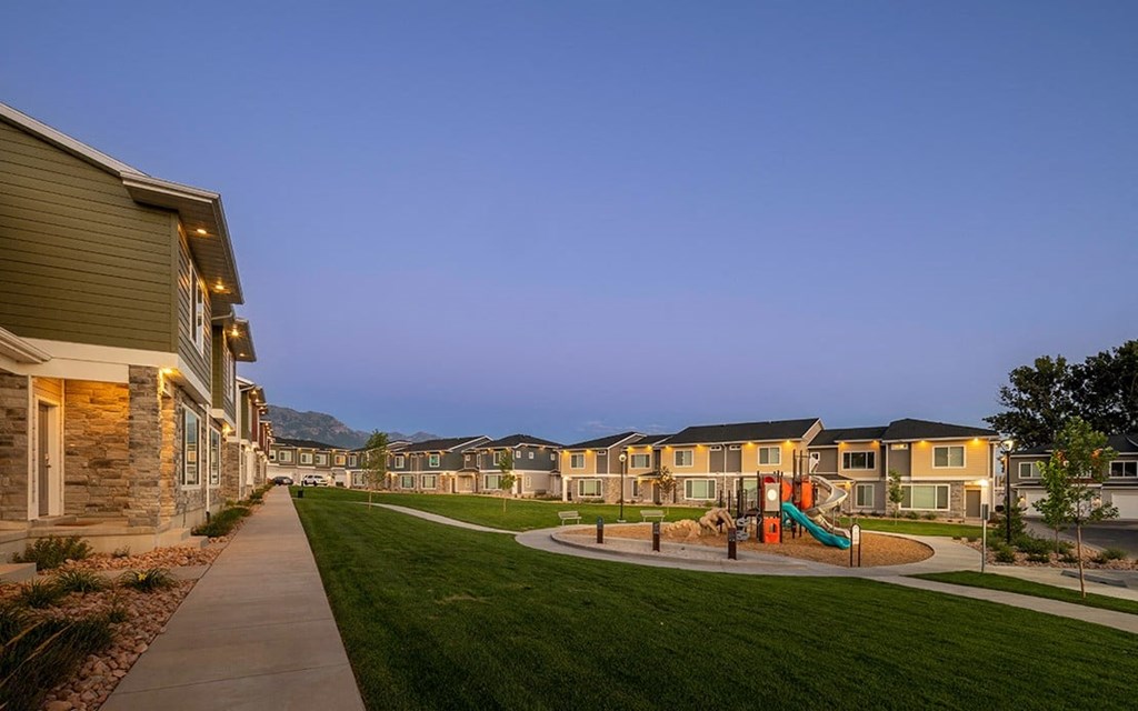 a playground is shown in front of a row of houses