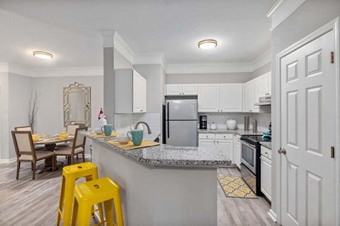 A kitchen with a table and chairs.