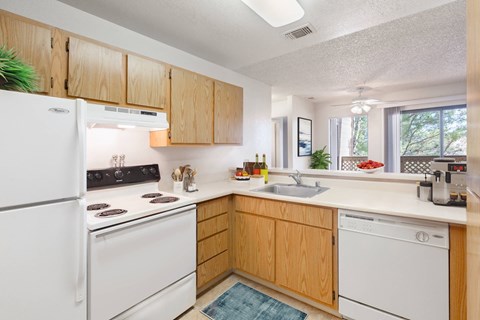 a kitchen with white appliances and wooden cabinets