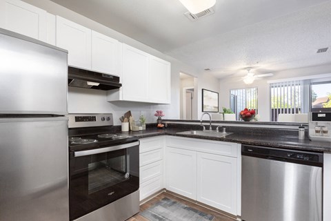 a kitchen with stainless steel appliances and white cabinets