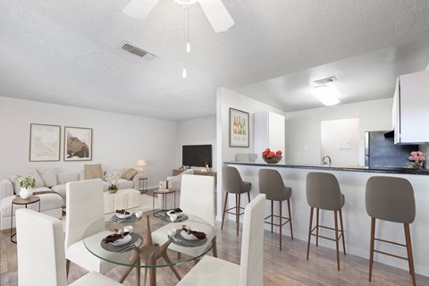 a living room and dining room with a glass table and chairs