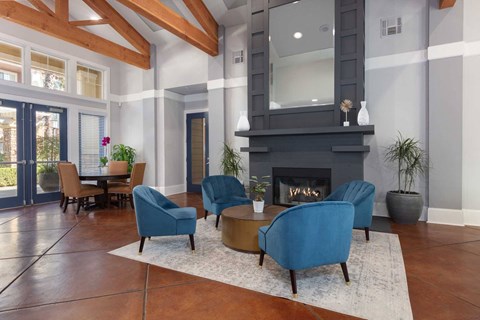A living room with a fireplace and blue chairs.