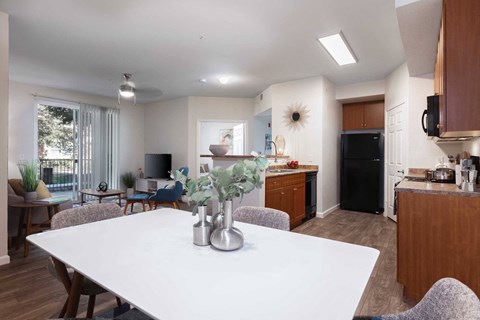 A modern kitchen with a dining table and chairs in the foreground.