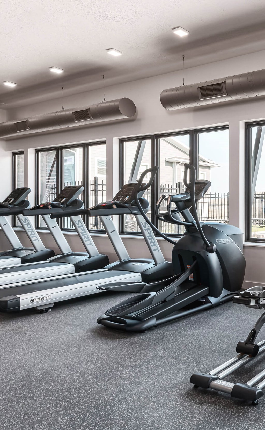 a gym with treadmills and other cardio equipment on the floor
