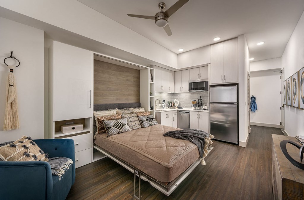 a bedroom with a bed and a kitchen