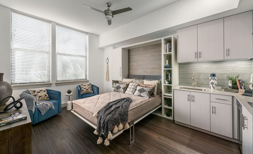 a bedroom with a bed and a living room with a kitchen