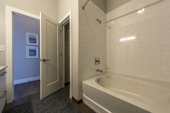 a bathroom with a tub and a shower and a door