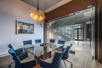 a dining room with a glass table and blue chairs