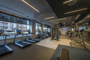 a gym with exercise equipment and large windows