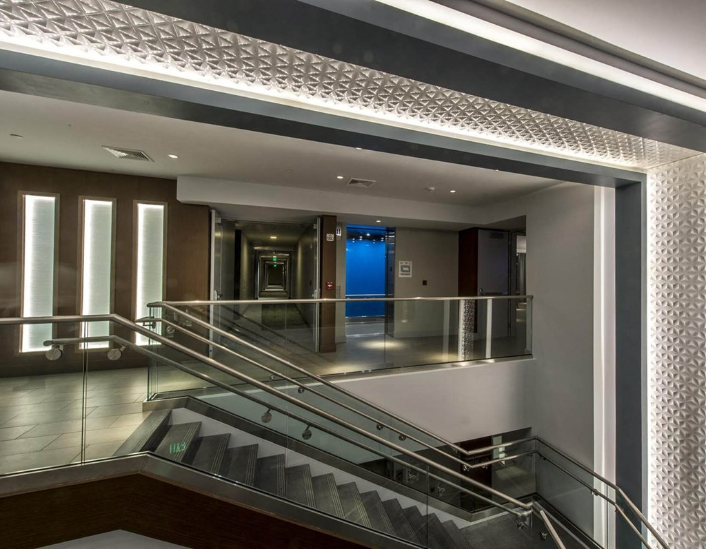 the lobby of a building with stairs and a blue door