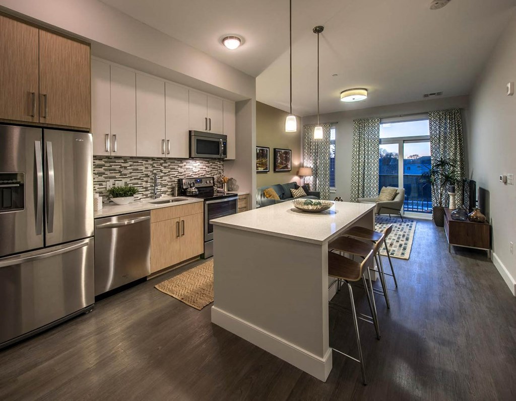 a kitchen with a large island and stainless steel appliances