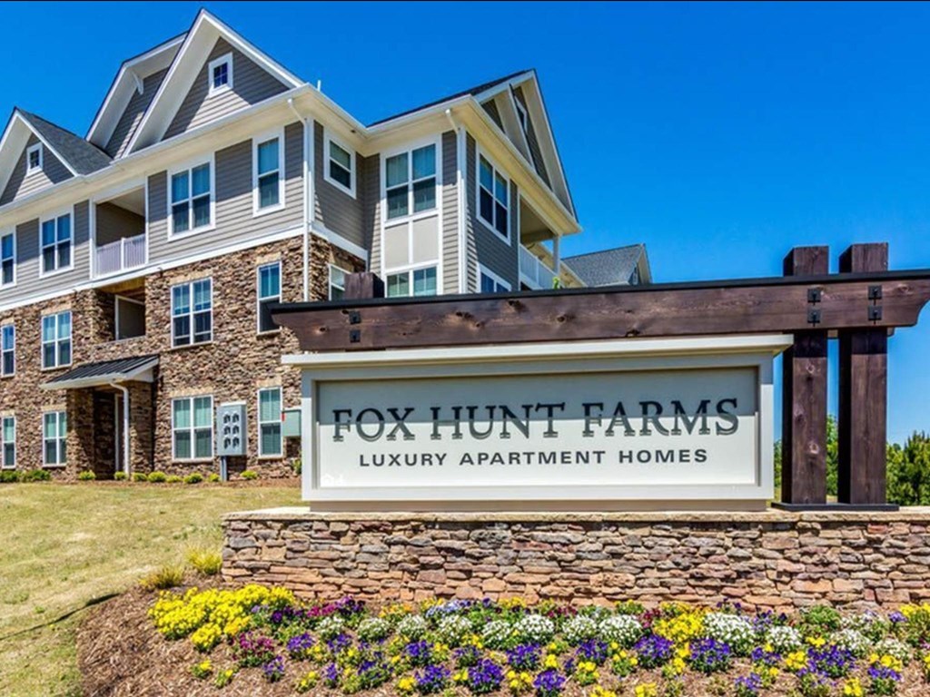 a large building with a sign for fox hunt farms luxury apartment homes