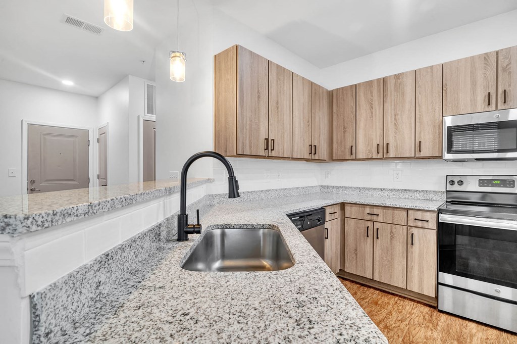 a kitchen with granite counter tops and wooden cabinets