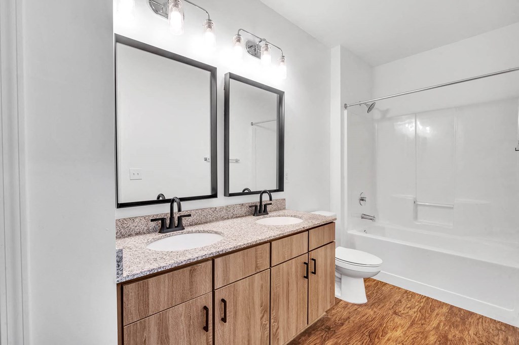 a bathroom with two mirrors and a toilet and a sink
