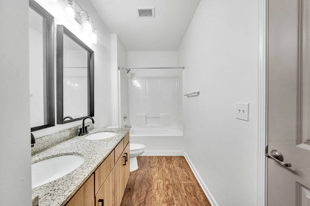 a bathroom with two sinks and a shower and a toilet