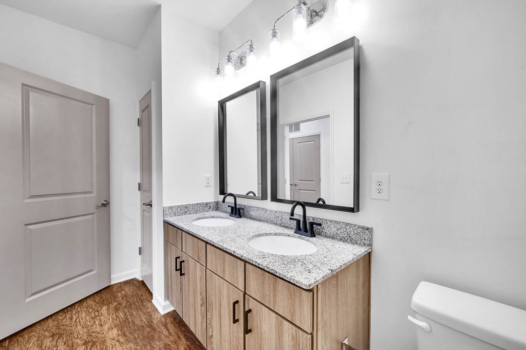 a bathroom with two sinks and two mirrors