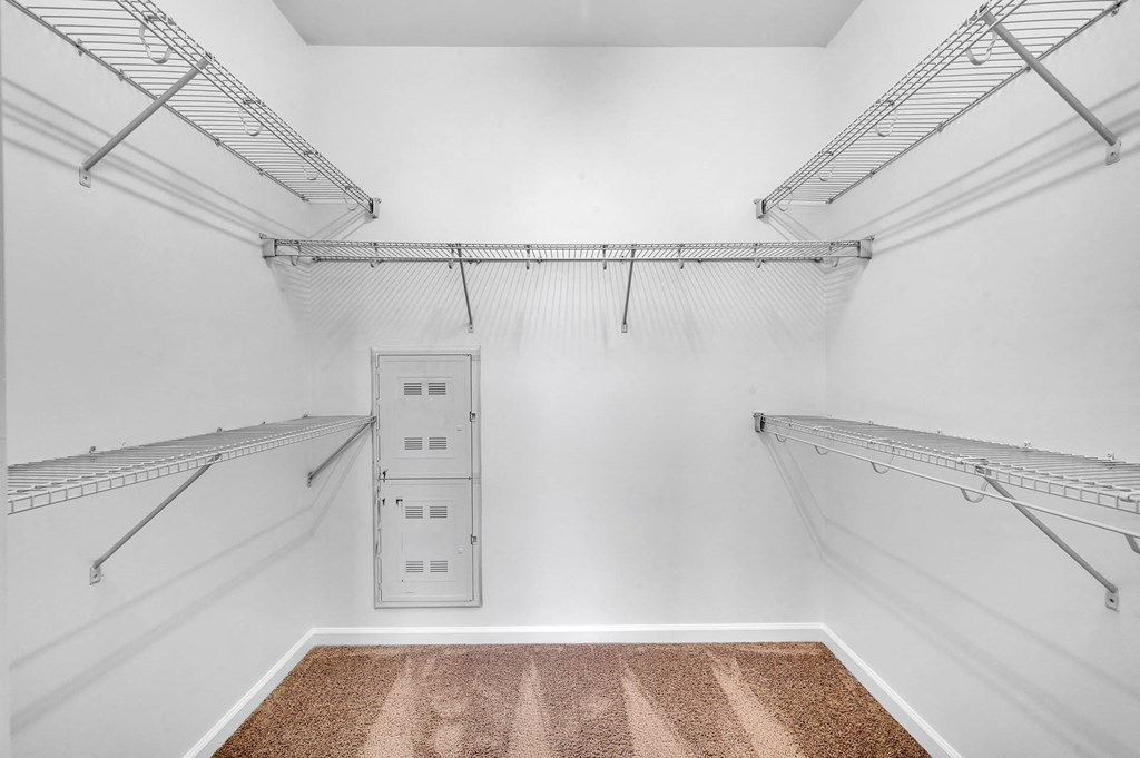 a large room with white walls and a mirrored closet