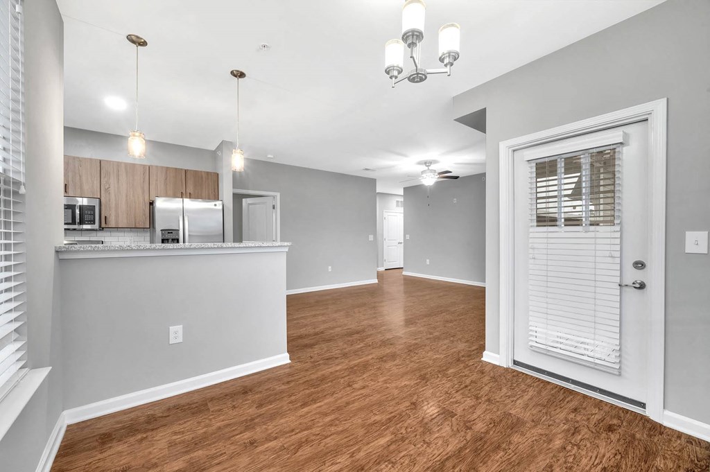 an open living room and kitchen with a door to the kitchen