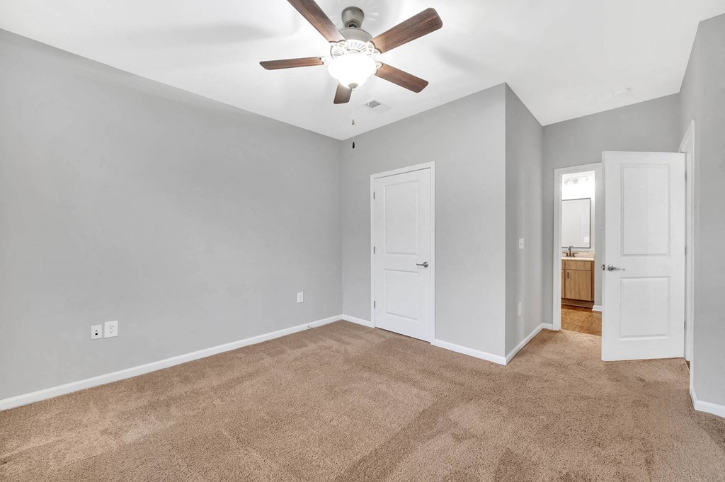 a living room with carpet and a ceiling fan