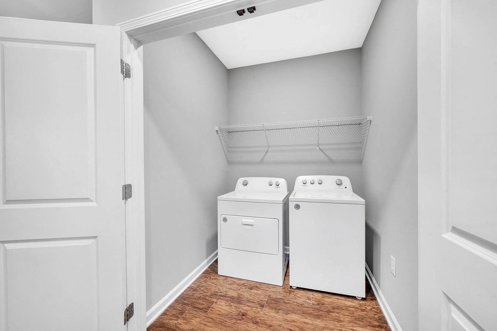 the laundry room of a home with two washes and a dryer