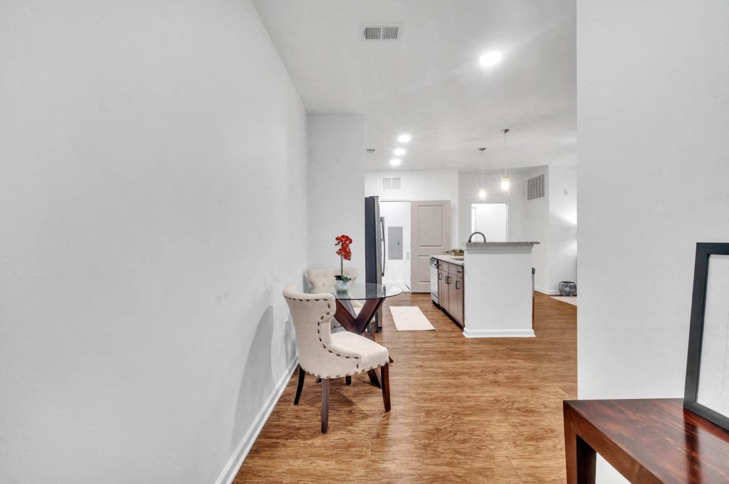 a living room and kitchen with a table and a chair