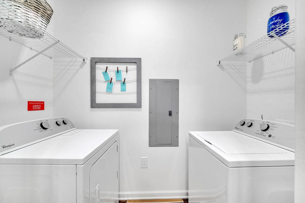 two washers and two dryers in a white laundry room with two white machines