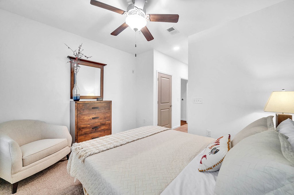 a bedroom with a bed and a ceiling fan