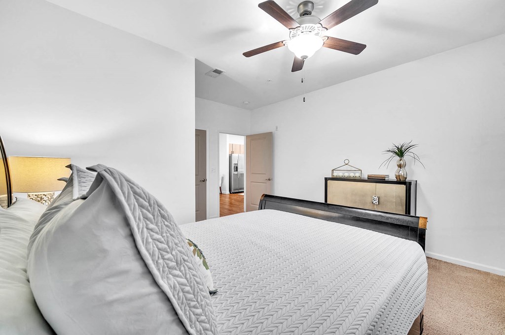 a bedroom with a large bed and a ceiling fan