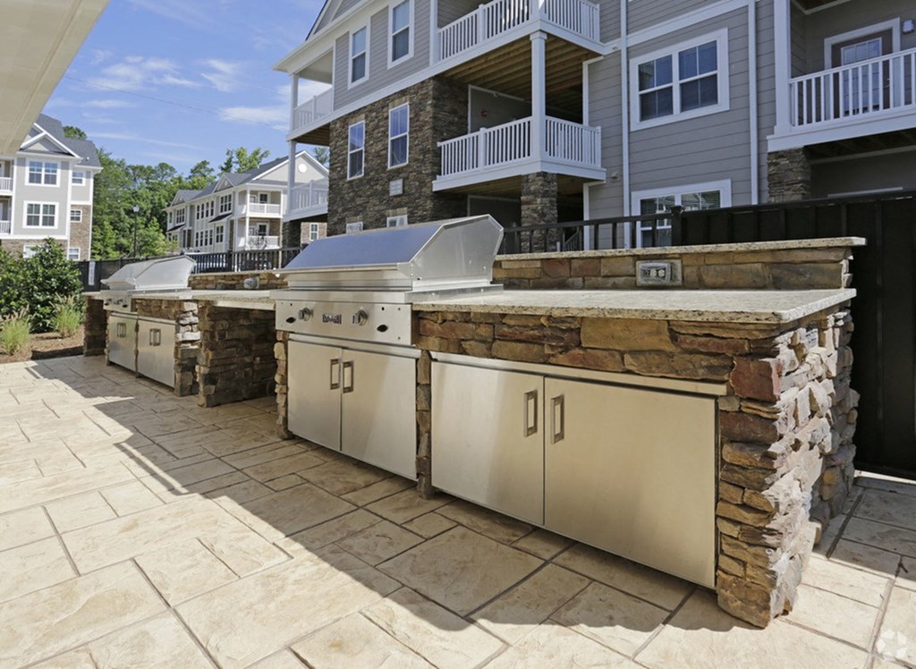 an outdoor kitchen with stainless steel appliances and a stone facade