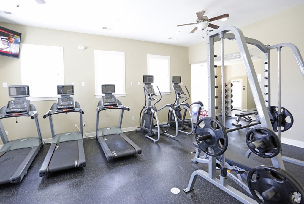 a gym with cardio machines and weights at the monarch apartments in midtown