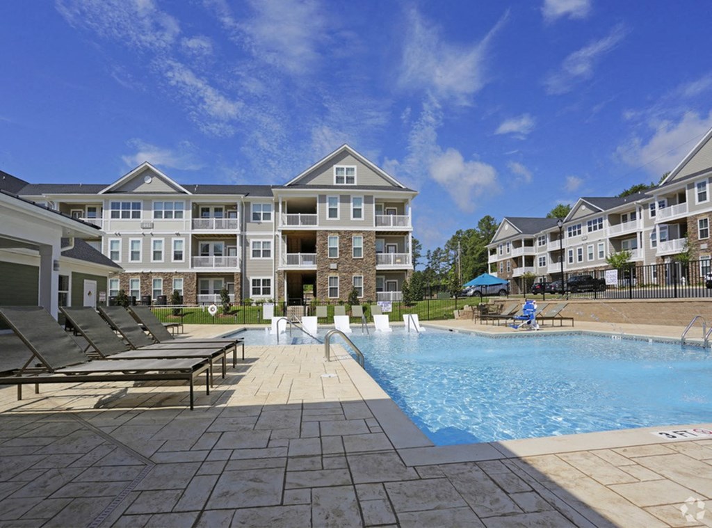 a swimming pool in front of an apartment building