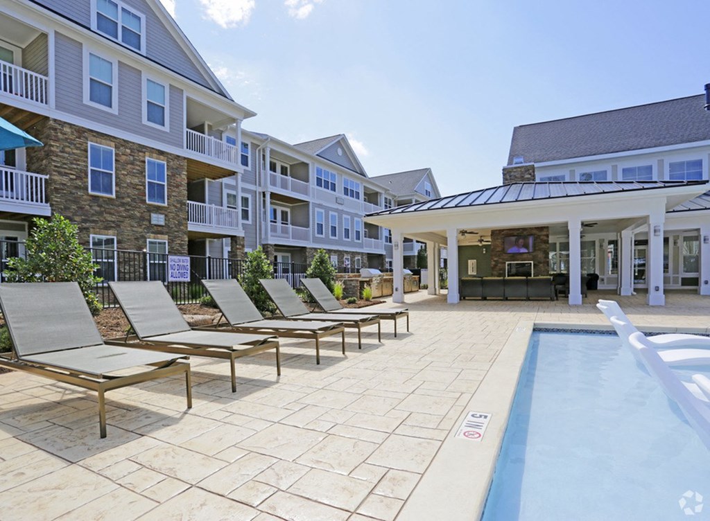 the preserve at ballantyne commons pool area with lounge chairs and a pool house