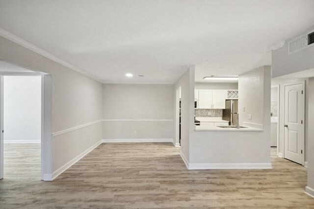 a renovated living room and kitchen with white walls and wood floors