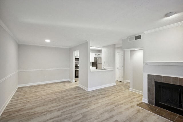 a empty living room with a fireplace and a kitchen