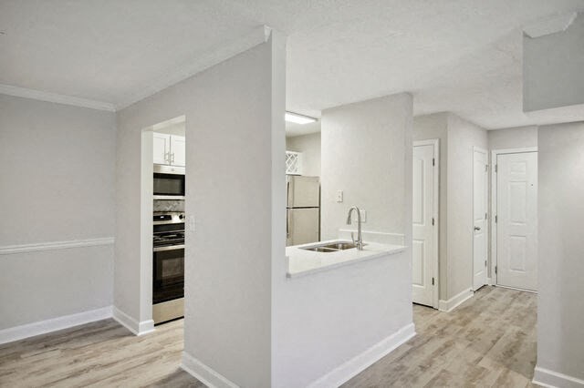 an empty living room with a kitchen and a sink
