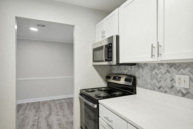 an empty kitchen with a stove and a microwave