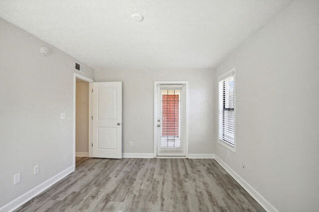 an empty living room with a door and a window