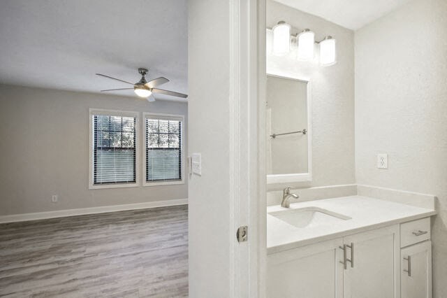 an empty bathroom with a sink and a ceiling fan