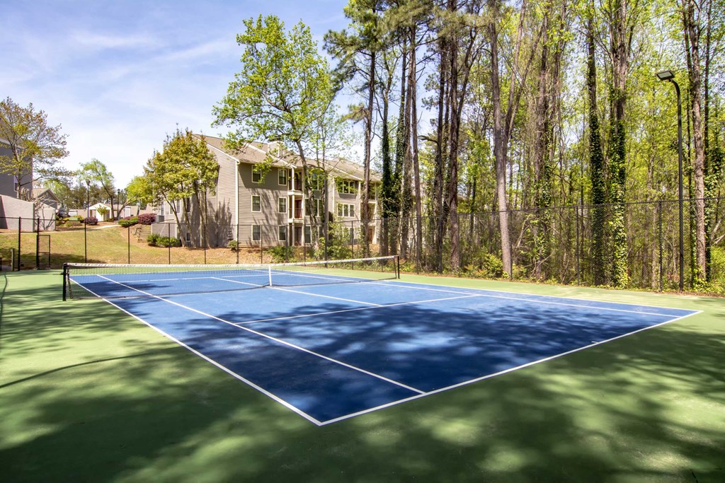 a tennis court with a house in the background