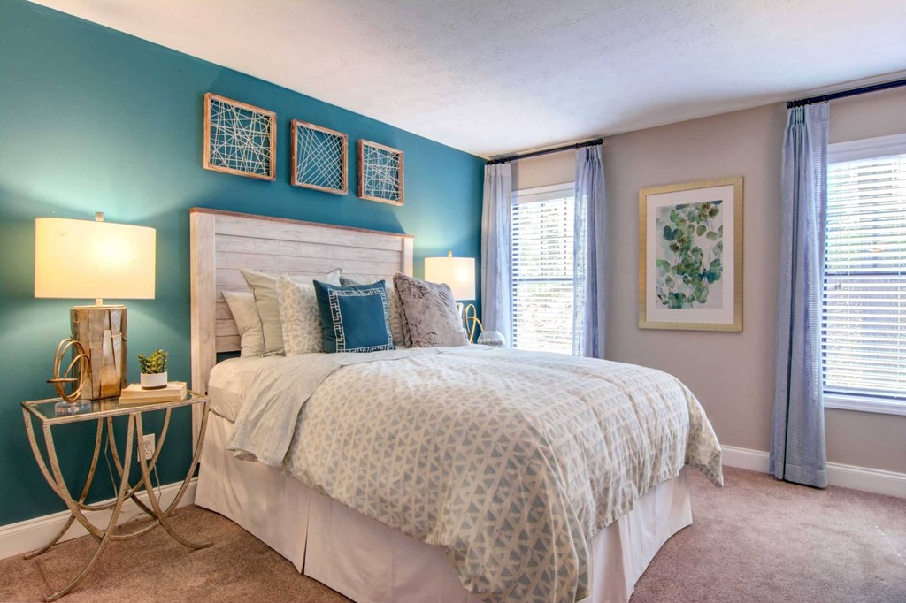 a bedroom with a bed and two windows