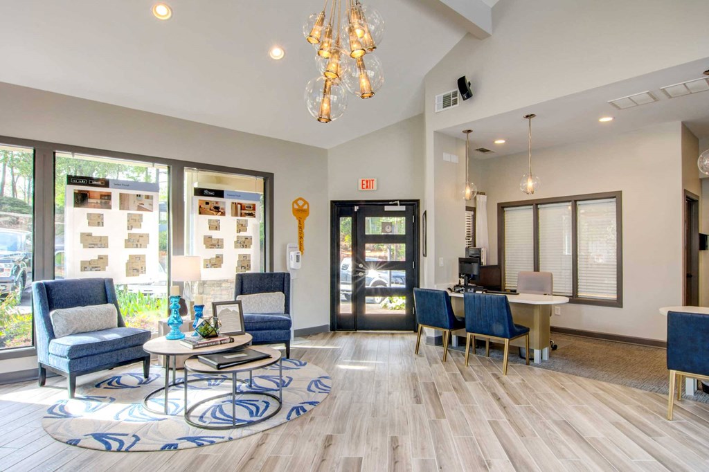 a lobby with blue chairs and a table and a glass door