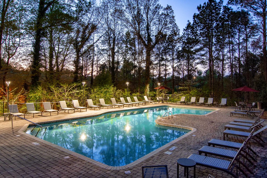 the pool is surrounded by lounge chairs at the resort