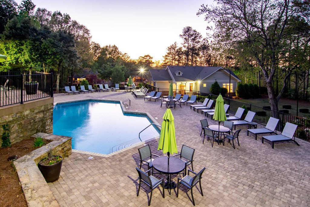 a swimming pool with tables and chairs around it