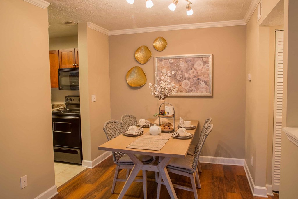 a dining room table with chairs and a painting on the wall