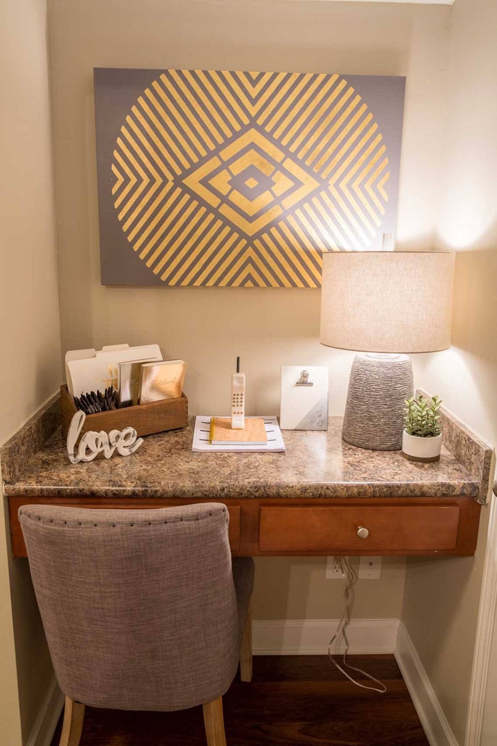 a desk with a lamp and a chair in a room