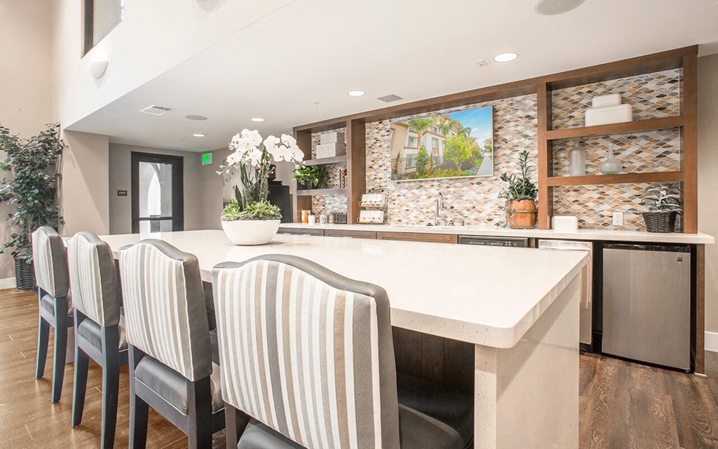 a kitchen with a large counter and chairs