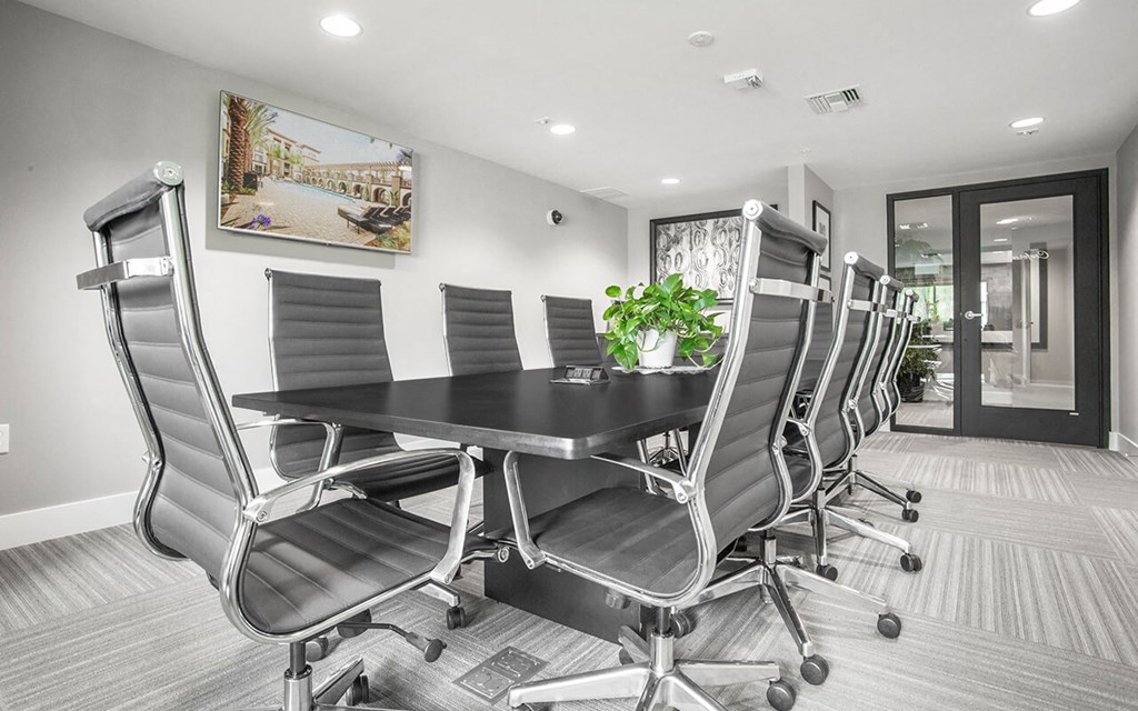 a conference room with a black table and chairs