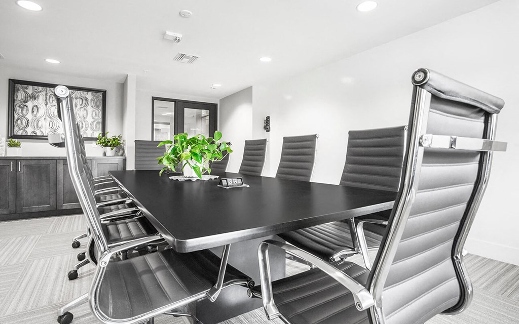 a conference room with a black table and chairs