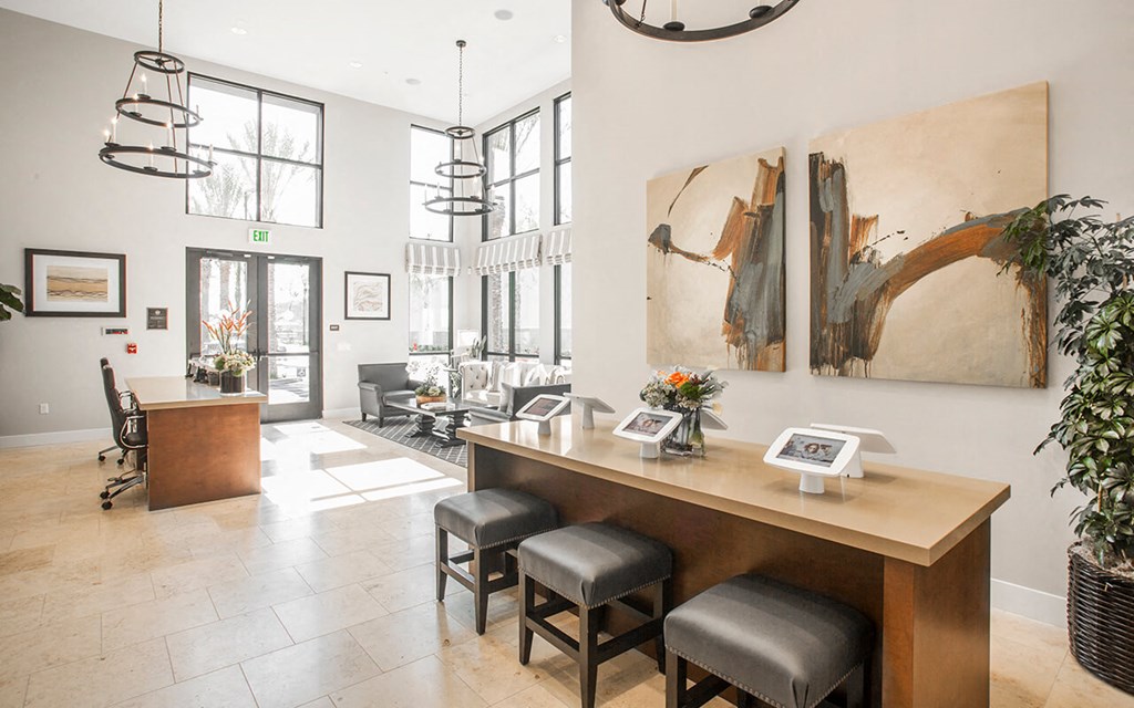 a living room with a wooden desk and chairs